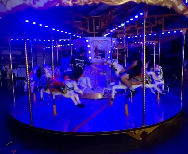 Lighted carousel rental glowing for an evening carnival event