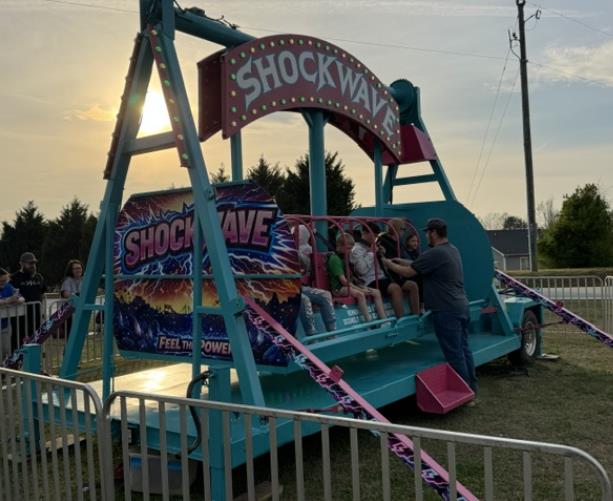 Shockwave carnival ride rental with bold panels and bright midway lights